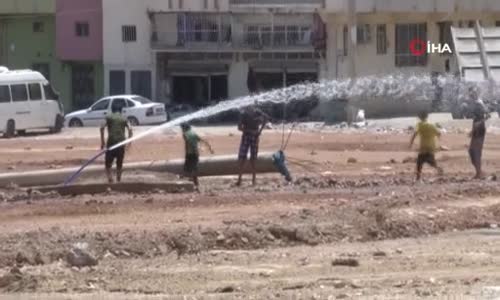 Sıcaktan bunalan çocuklar çamurda halay çekip hortumla serinledi 